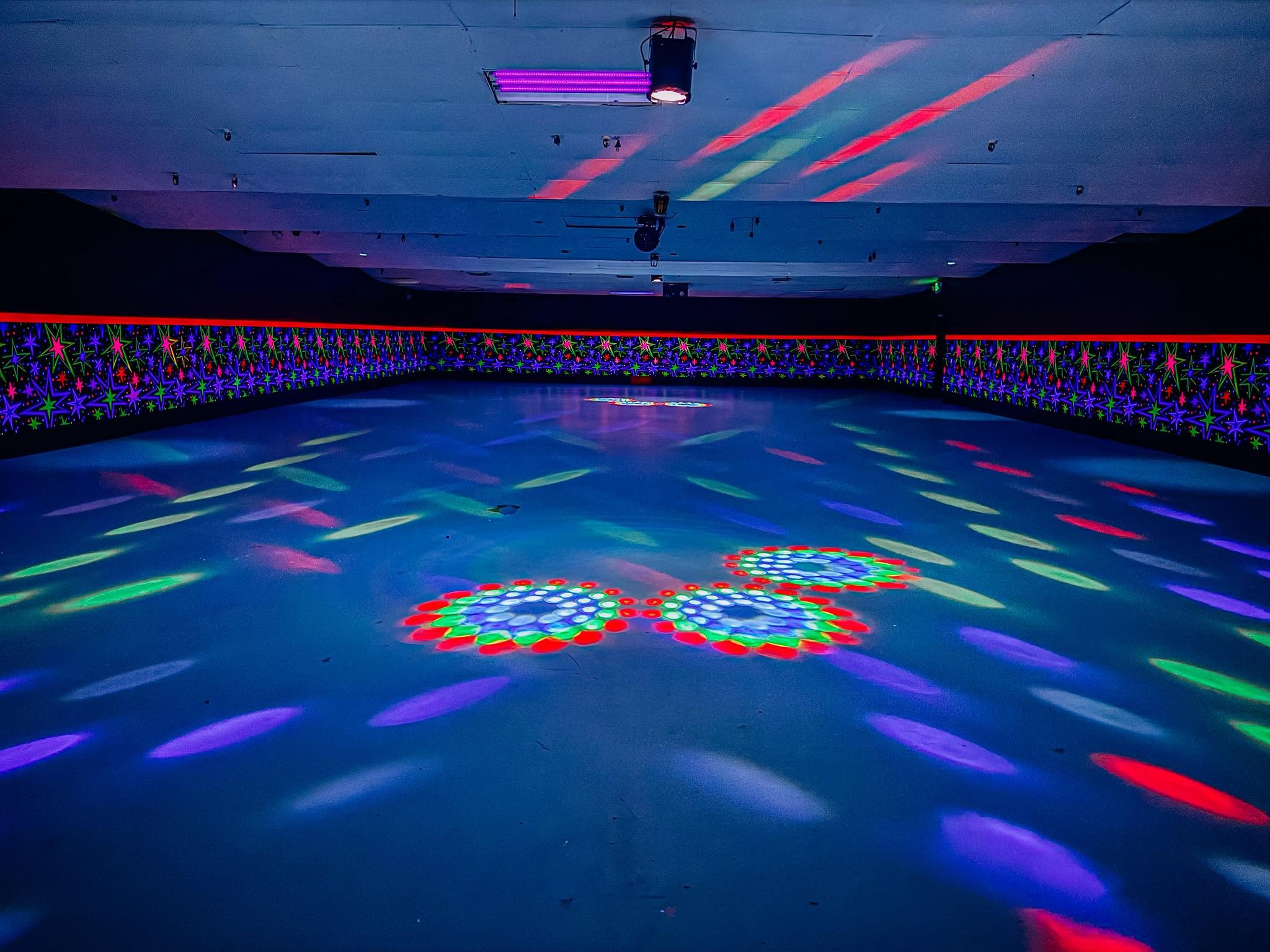 Idletime's cosmic skating floor glowing under colorful lights